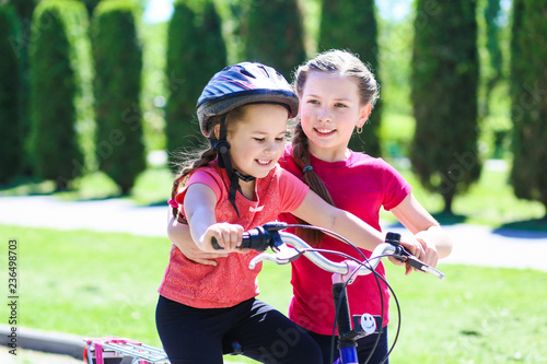 fun children ride a bike. Smiling kids summer vacation