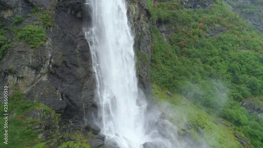Aerial slow motion shot of raging white water mountain river waterfall flowing down in rocky mountains in Norway Aerial slow motion shot of raging white water mountain river waterfall flowing down in rocky mountains in Norway