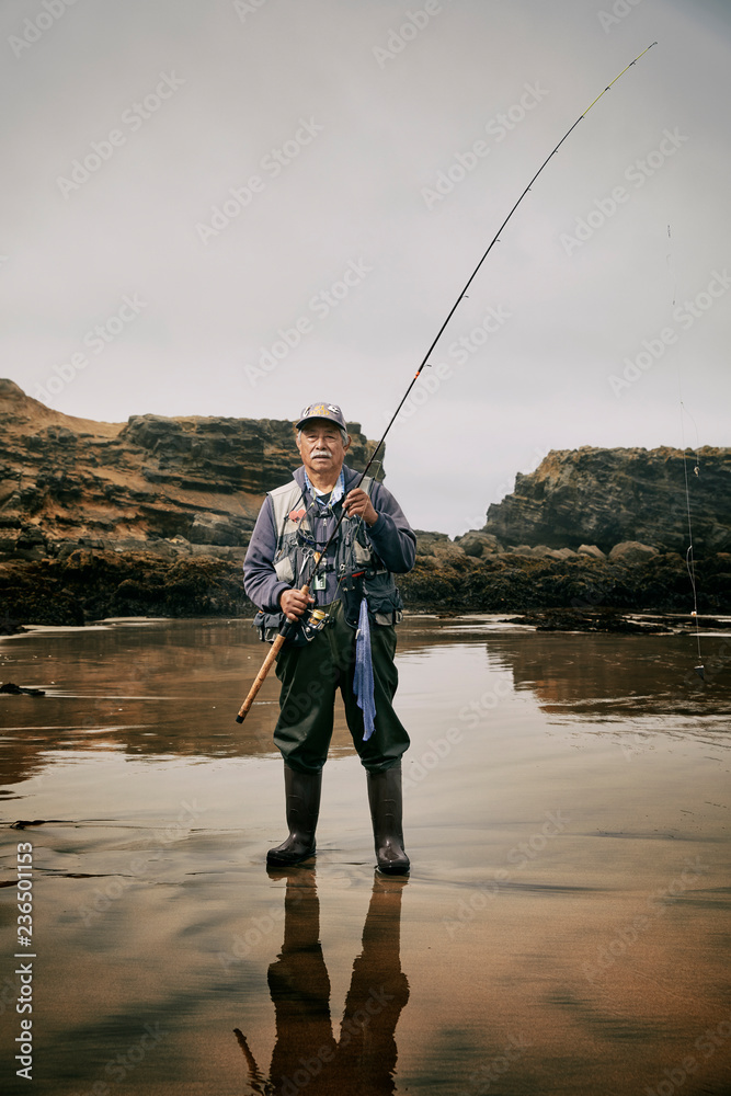 Portrait of retired fisherman standing in ocean Portrait of retired fisherman standing in ocean