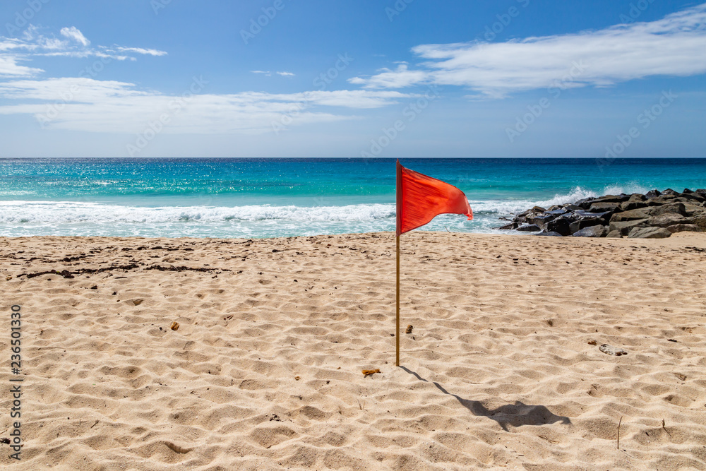 A red warning flag on a caribbean beach