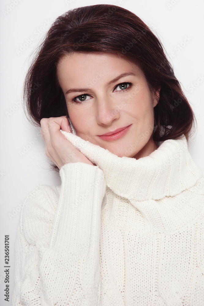 Portrait of attractive smiling mature woman in white pullover Portrait of attractive smiling mature woman in white pullover