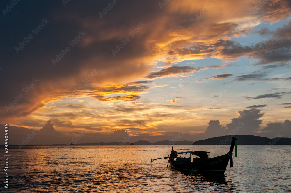 Long tail fishing boat at sunset, Koh Phi Phi, Thailand.