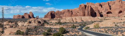 Panoramic Landscape view of a Scenic road in the red rock canyons during a vibrant sunny day. Taken in Arches National Park, located near Moab, Utah, United States.