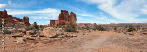 Panoramic landscape view of beautiful red rock canyon formations during a vibrant sunny day. Taken in Arches National Park  located near Moab  Utah  United States.