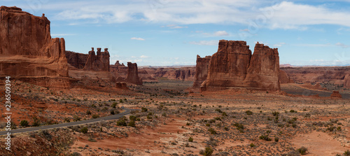 Panoramic landscape view of a Scenic road in the red rock canyons during a vibrant sunny day. Taken in Arches National Park, located near Moab, Utah, United States. © edb3_16