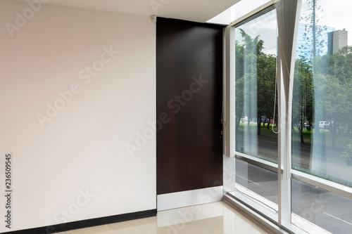 Interior of modern office with large window and wooden door  new space with reflections  latin america.