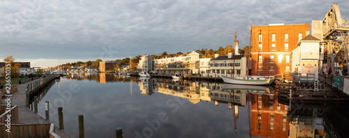 Mystic, Stonington, Connecticut, United States - October 26, 2018: Panoramic view of old historic homes by the Mystic River during a vibrant sunrise.