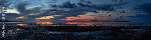 Striking panoramic seascape view on a rocky Atlantic Ocean Coast during a vibrant sunset. Taken at Cow Head  Newfoundland and Labrador  Canada.