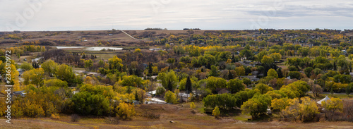 Aerial Panoramic view of a small Town in the Prairies during a vibrant sunny day in the Fall Season. Taken in Lumsden, Saskatchewan, Canada