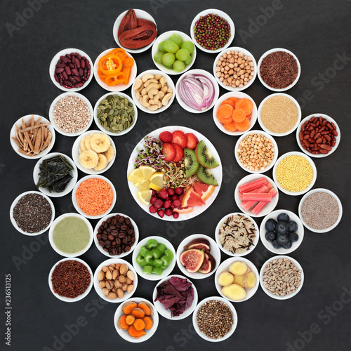 Super food for losing weight concept including fruit, vegetables, grains, nuts, seeds, spices, coffee, supplement powders, and herbs on slate background. 