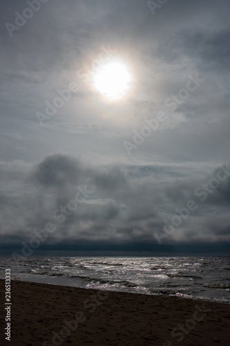 storm clouds forming over clear sea beach with rocks and clear sand © Martins Vanags