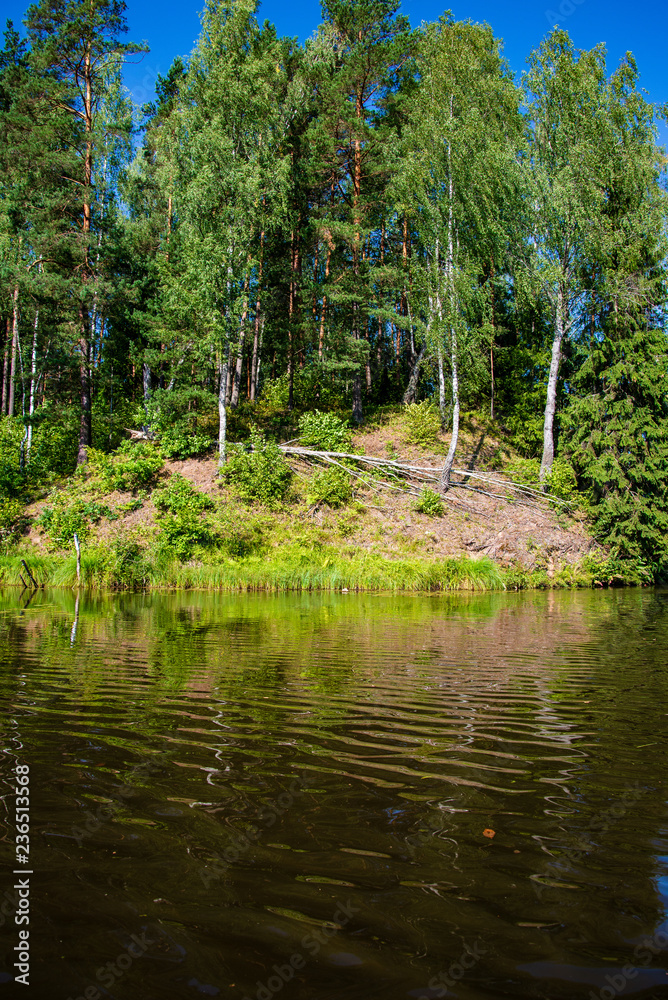 summer day on water in calm river enclosed in forests with sandstone cliffs and dry wood summer day on water in calm river enclosed in forests with sandstone cliffs and dry wood