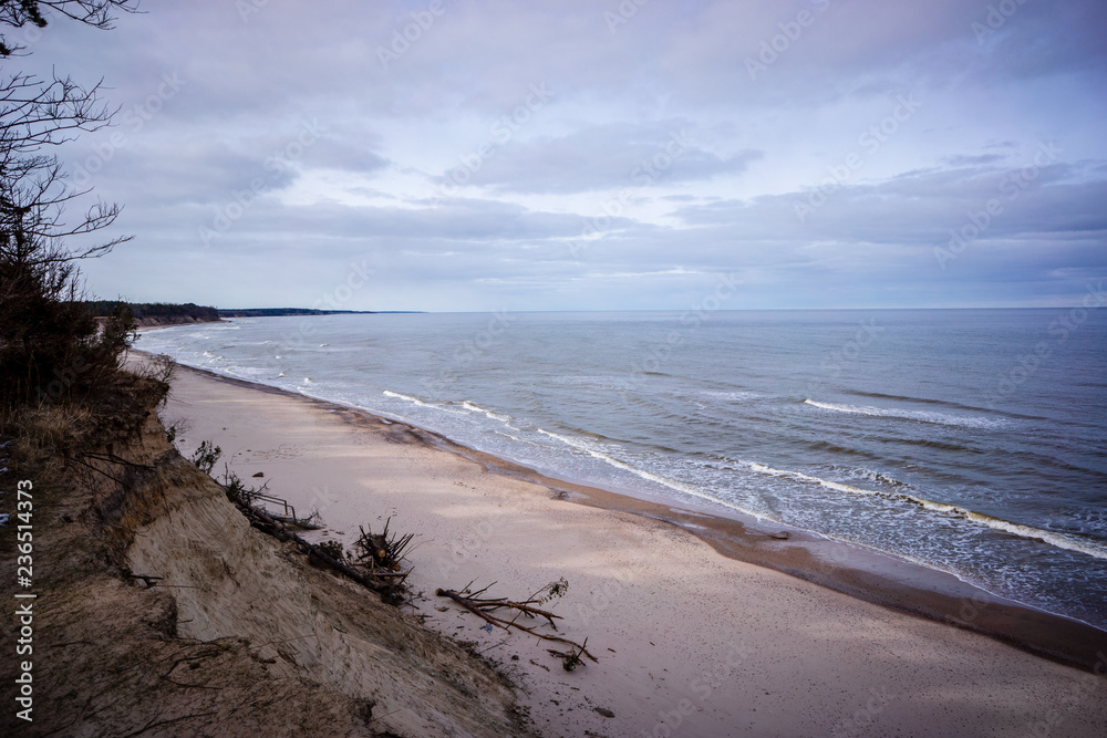 storm clouds forming over clear sea beach with rocks and clear sand