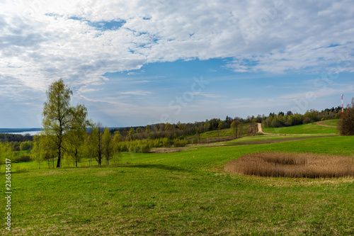 plain simple countryside spring landscape with fresh green meadows and forests