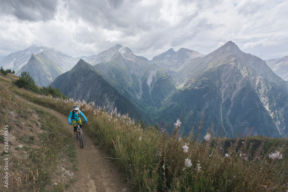 Anonymous person mountain biking on backcountry route in mountains Anonymous person mountain biking on backcountry route in mountains