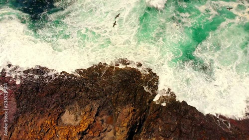 Waves crashing against rocks with spectacular sea sprays. photo