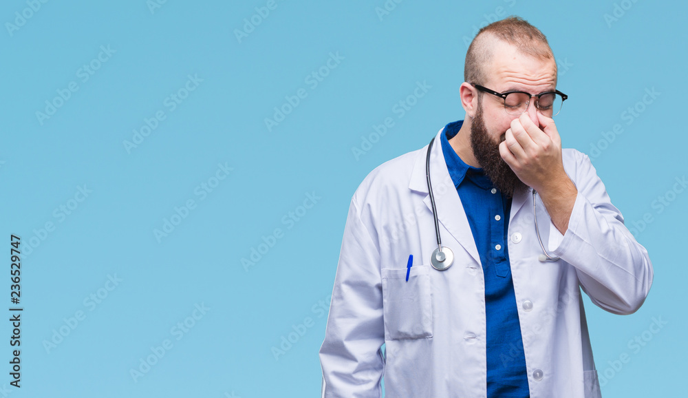 Young caucasian doctor man wearing medical white coat over isolated background tired rubbing nose and eyes feeling fatigue and headache. Stress and frustration concept. Young caucasian doctor man wearing medical white coat over isolated background tired rubbing nose and eyes feeling fatigue and headache. Stress and frustration concept.