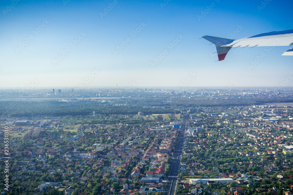 Taking off from Otopeni airport; flying over residential neighborhoods, Bucharest skyline in the background; Romania Taking off from Otopeni airport; flying over residential neighborhoods, Bucharest skyline in the background; Romania