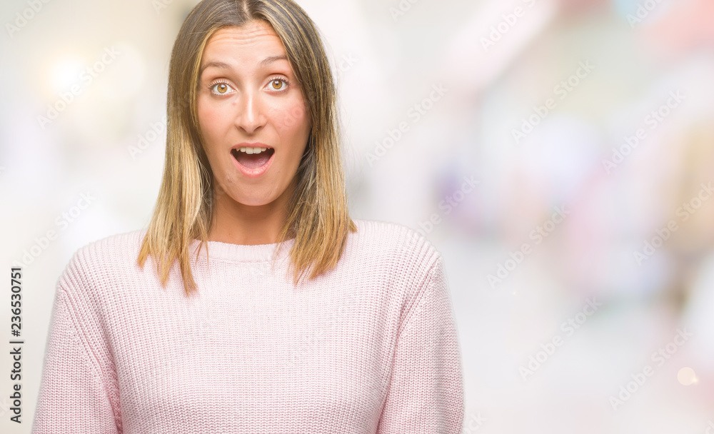 Fototapeta premium Young beautiful woman wearing winter sweater over isolated background afraid and shocked with surprise expression, fear and excited face.