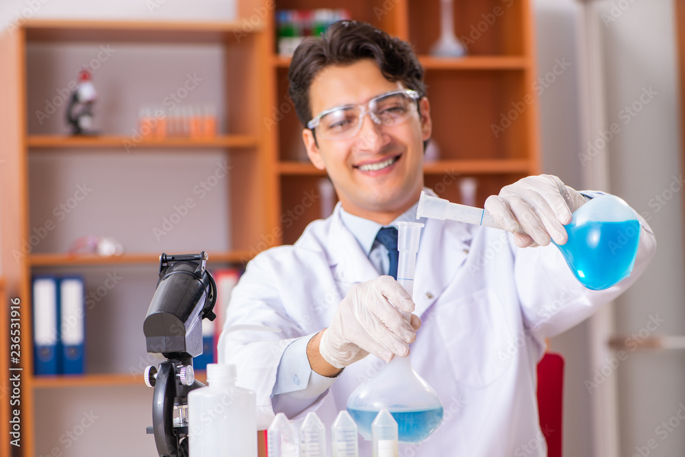 Young handsome biochemist working in the lab Young handsome biochemist working in the lab