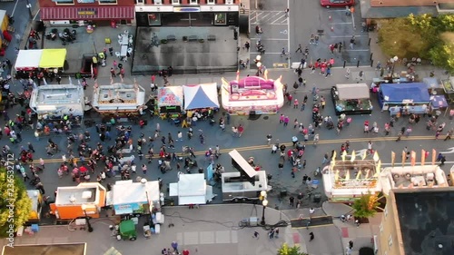 Drone, flying sideways, over people at street fair in Pennsylvania