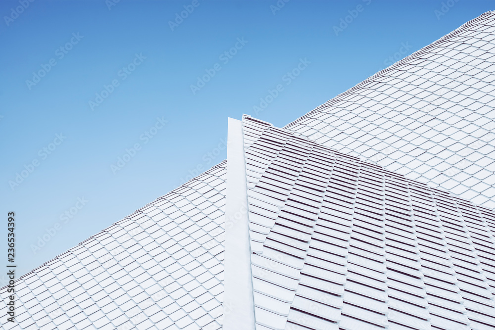 Close up of abstract geometric structure white wall and roof top against blue sky . Close up of abstract geometric structure white wall and roof top against blue sky .