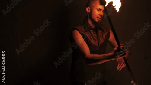 Slowmotion shot of man spinning staff with wall behind