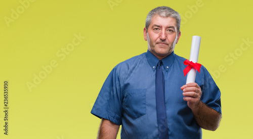 Handsome senior man holding degree over isolated background with a confident expression on smart face thinking serious