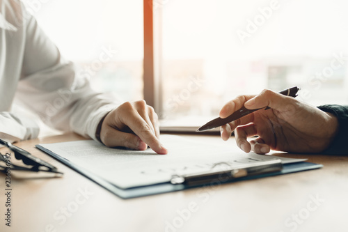 Business advisor financial man pointing on contract paper to customer reading contract.