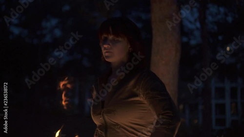 Slowmotion shot of woman spinning poi in woods at dusk photo