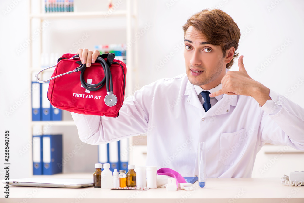 Young doctor with first aid kit in hospital Young doctor with first aid kit in hospital