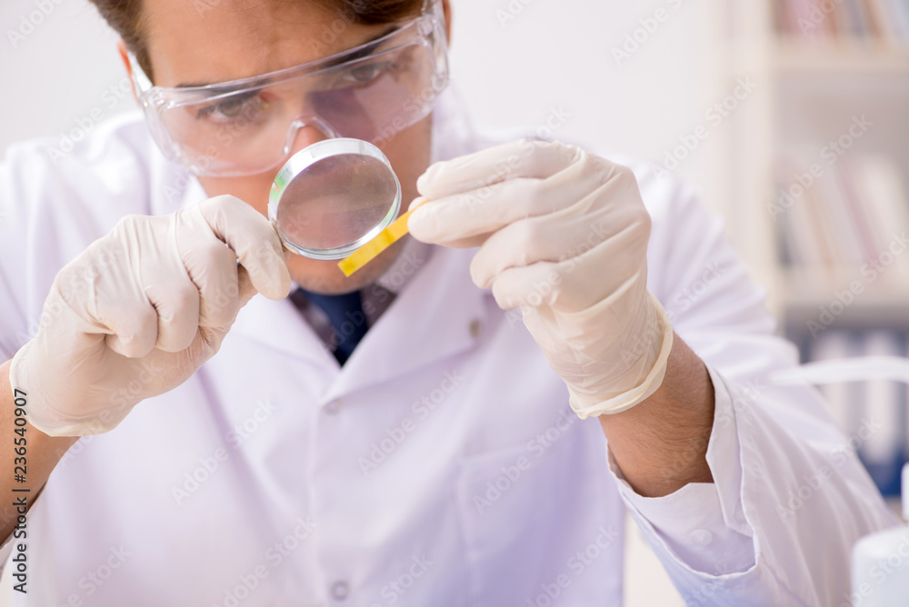 Chemist in the lab checking with ph strips Chemist in the lab checking with ph strips