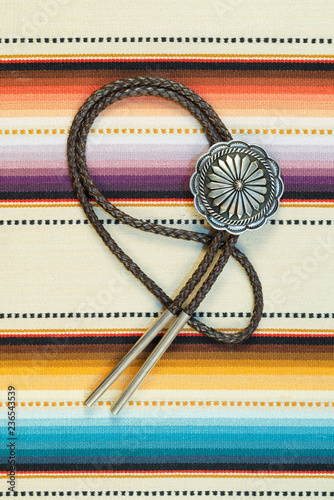 Vintage Sterling Silver Bolo Tie with Concho andSilver Tips on colorful southwestern hand woven fabric.