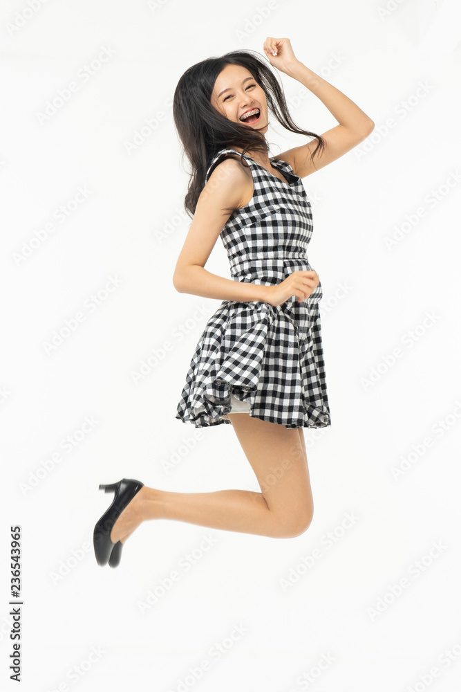 Naklejka premium portrait of excited surprised attractive inspired girl jumping up isolated on background.Freedom legs stylish feet glamorous people teenager asian.