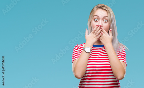 Young blonde woman over isolated background shocked covering mouth with hands for mistake. Secret concept.
