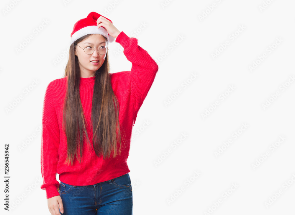 Young Chinese woman over isolated background wearing christmas hat confuse and wonder about question. Uncertain with doubt, thinking with hand on head. Pensive concept. Young Chinese woman over isolated background wearing christmas hat confuse and wonder about question. Uncertain with doubt, thinking with hand on head. Pensive concept.