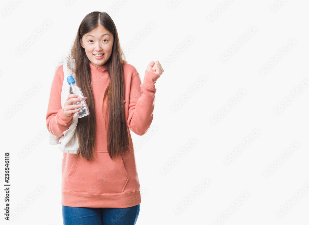Young Chinese woman over isolated background wearing sport sweathshirt screaming proud and celebrating victory and success very excited, cheering emotion Young Chinese woman over isolated background wearing sport sweathshirt screaming proud and celebrating victory and success very excited, cheering emotion