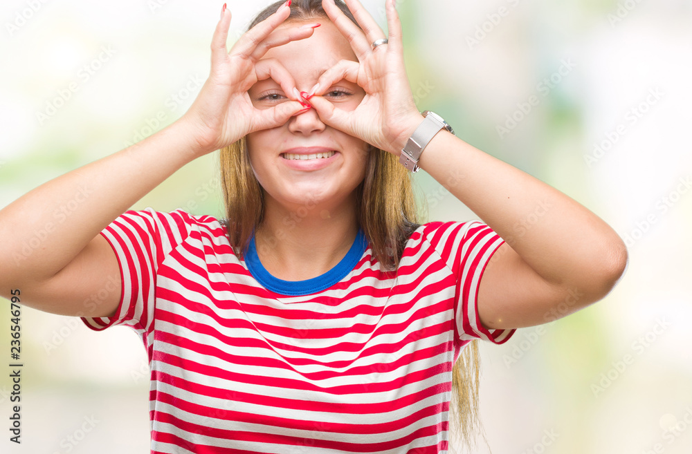 Young caucasian beautiful woman over isolated background doing ok gesture like binoculars sticking tongue out, eyes looking through fingers. Crazy expression.