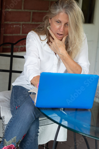 Mature blonde woman shocked by something on the internet