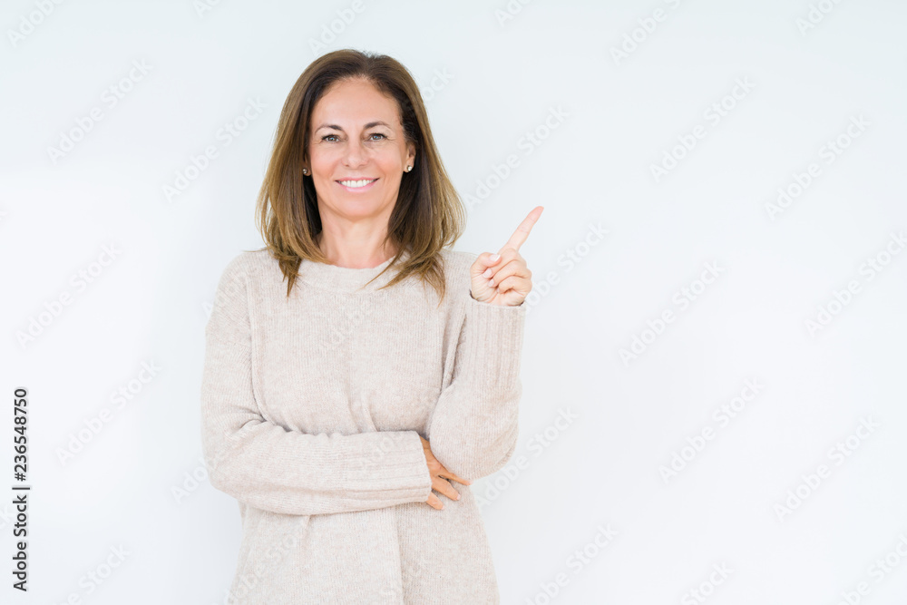 Beautiful middle age woman over isolated background with a big smile on face, pointing with hand and finger to the side looking at the camera. Beautiful middle age woman over isolated background with a big smile on face, pointing with hand and finger to the side looking at the camera.