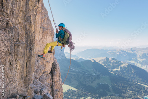 Female rock climber hanging on safety rope