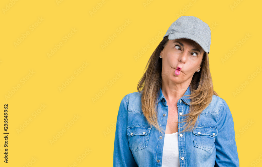Beautiful middle age woman wearing sport cap over isolated background making fish face with lips, crazy and comical gesture. Funny expression. Beautiful middle age woman wearing sport cap over isolated background making fish face with lips, crazy and comical gesture. Funny expression.