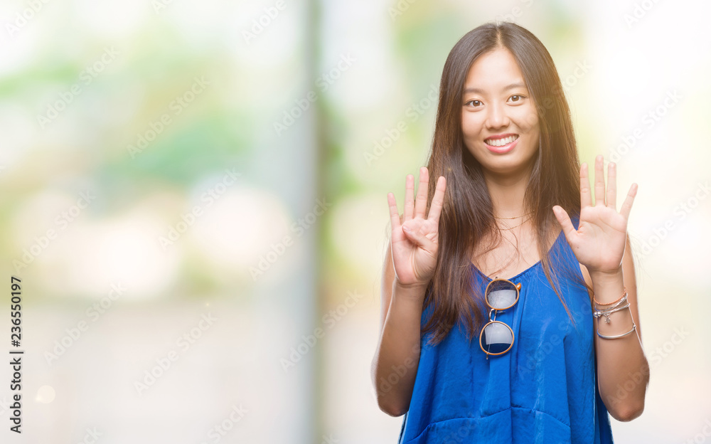 Young asian woman over isolated background showing and pointing up with fingers number nine while smiling confident and happy. Young asian woman over isolated background showing and pointing up with fingers number nine while smiling confident and happy.