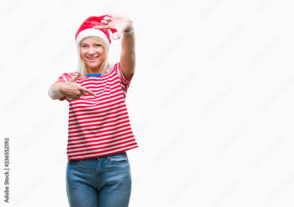 Young beautiful blonde woman wearing christmas hat over isolated background smiling making frame with hands and fingers with happy face. Creativity and photography concept.