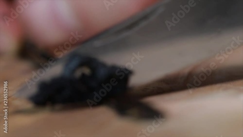 Vanilla Pod is Scraped Out with a Knife (hand visible), Closeup