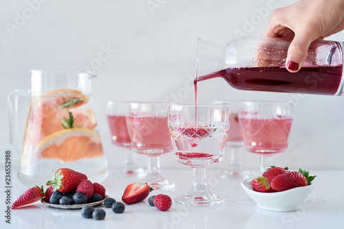 pouring homemade syrup into sparkling water for mocktail photo