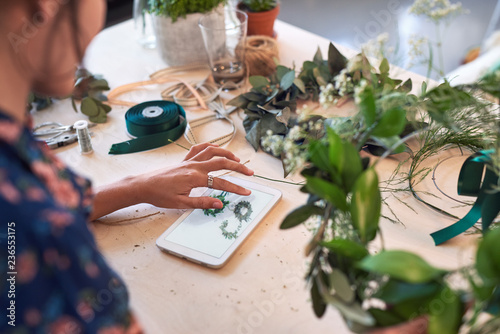 Woman referring to reference picture while crafting 