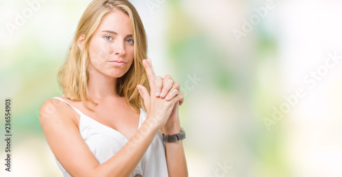 Beautiful young woman over isolated background Holding symbolic gun with hand gesture, playing killing shooting weapons, angry face