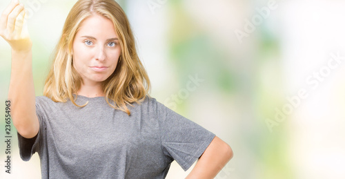 Beautiful young woman wearing oversize casual t-shirt over isolated background Doing Italian gesture with hand and fingers confident expression