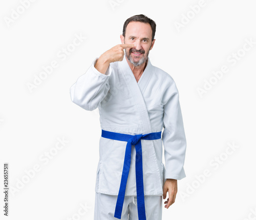 Handsome middle age senior man wearing kimono uniform over isolated background Pointing with hand finger to face and nose, smiling cheerful